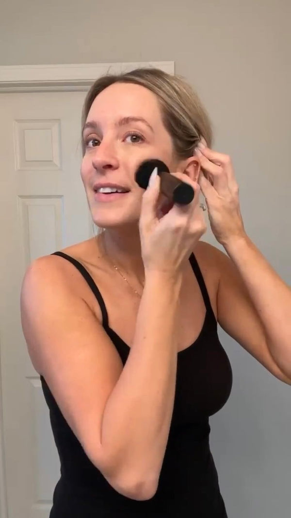 Samantha Hermann @houseplusplant applying self tanner to her face with a kabuki brush