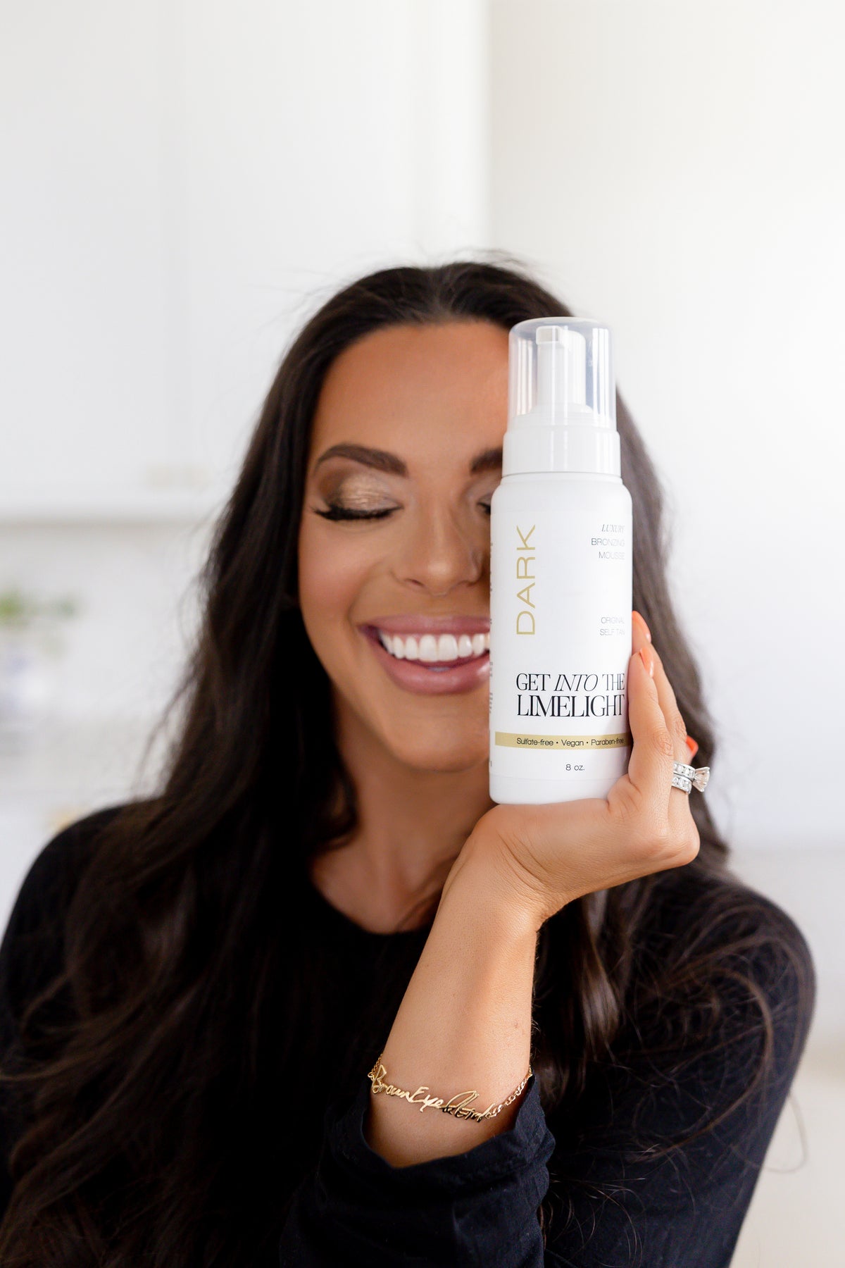 Get Into The Limelight Founder Lindsay Schneider holding Get Into The Limelight Dark Self-Tanning Mousse